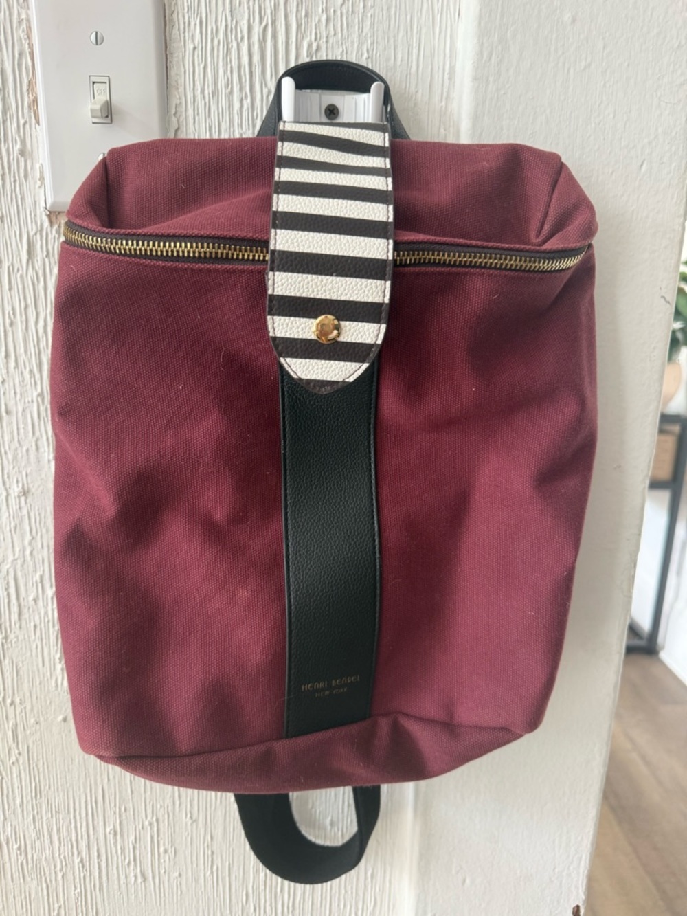 henri bendel burgundy backpack with black trim and striped tab